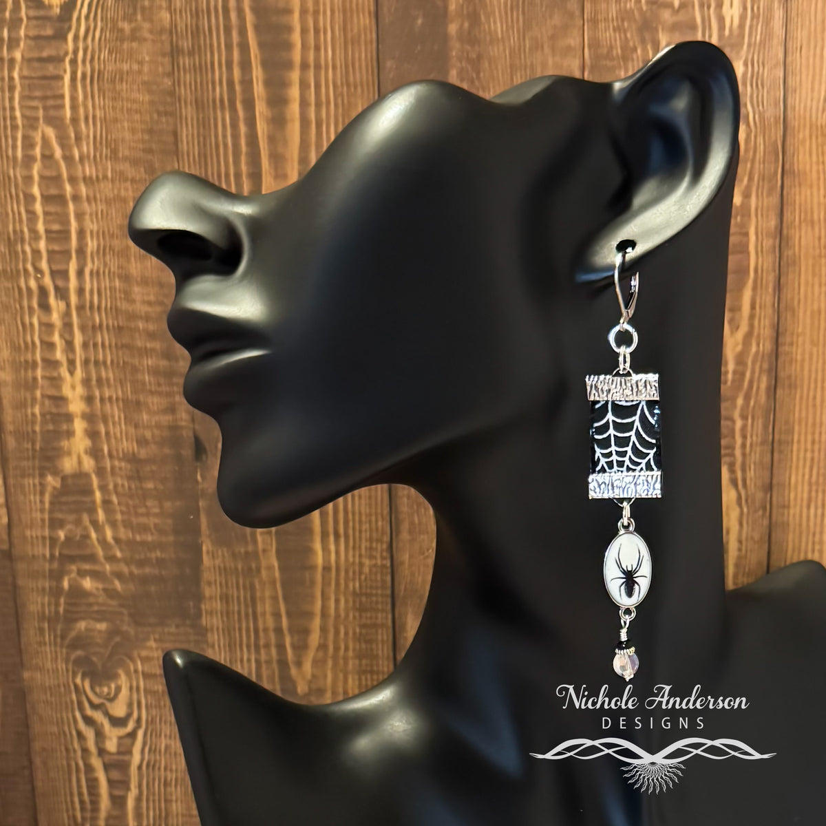 Spider web ribbon earring on a black mannequin ear with wooden background