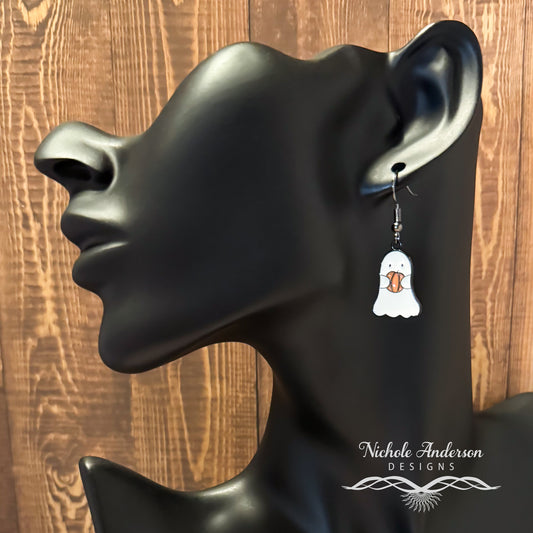 A ghost holding a pumpkin earring hanging from a black mannequin ear
